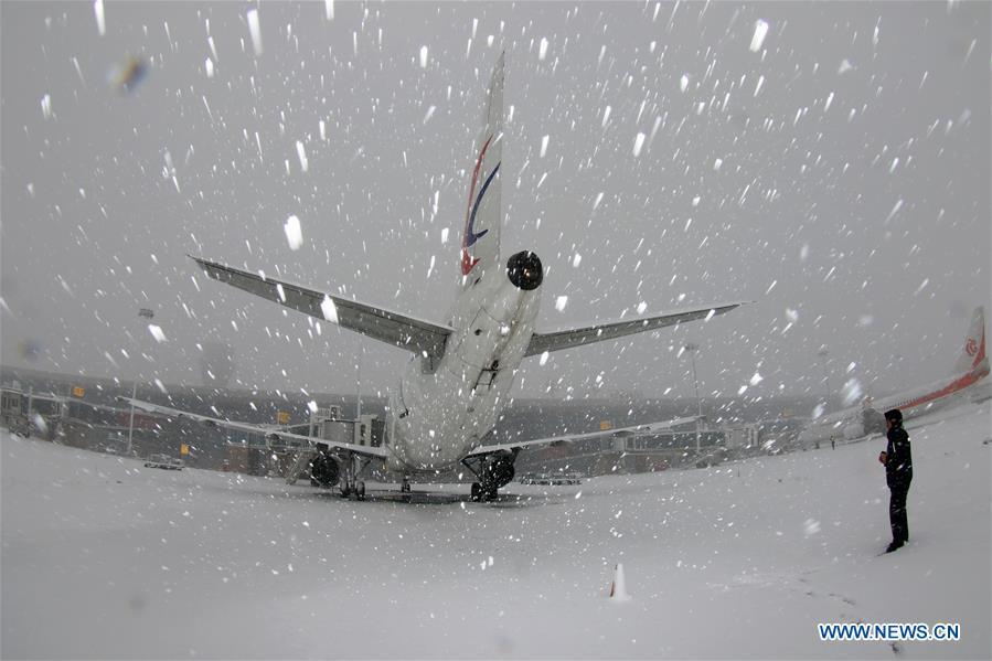 A staff worker checks an aircraft in snow at Yantai Penglai International Airport in Yantai City, east China\'s Shandong Province, Dec. 11, 2018. Parts of Shandong Province met snow on Tuesday. (Xinhua/Tang Ke)