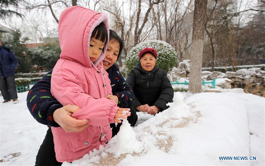A child makes a snow cone in Weifang City, east China\'s Shandong Province, Dec. 11, 2018. Parts of Shandong Province met snow on Tuesday. (Xinhua/Zhang Chi)