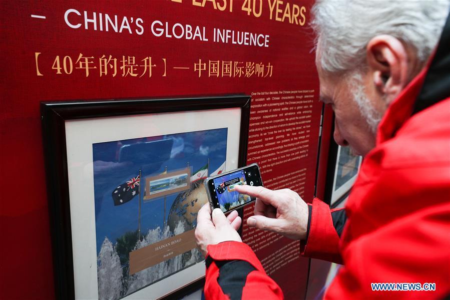 A visitor takes photos of the stamps showing China\'s global influence during the \