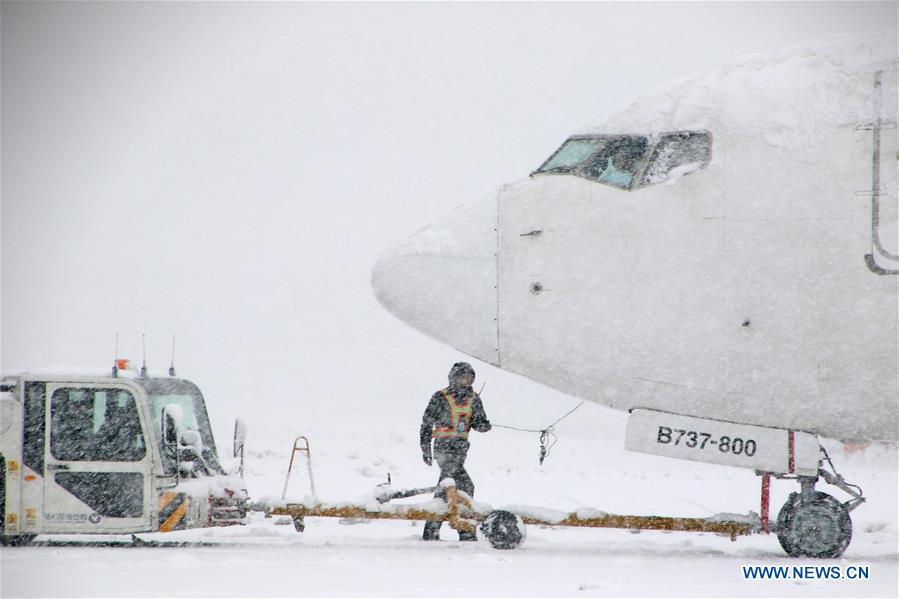 A tractor tows an aircraft in snow at Yantai Penglai International Airport in Yantai City, east China\'s Shandong Province, Dec. 11, 2018. Parts of Shandong Province met snow on Tuesday. (Xinhua/Tang Ke)