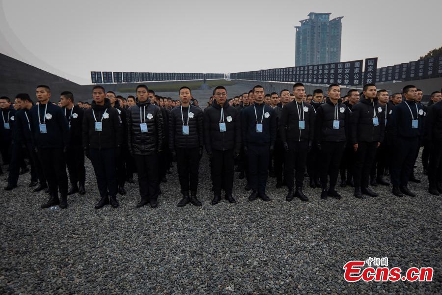 A ceremony is held at the Memorial Hall for the Victims of the Nanjing Massacre in Nanjing, Jiangsu Province, Dec. 13, 2018. On Thursday, China marked the fifth national memorial day to commemorate the victims of the Nanjing Massacre, in which Japanese invaders slaughtered about 300,000 Chinese during a six-week rampage after they captured the city, then China\'s capital, in 1937. In front of the darkly-dressed crowd at the ceremony, China\'s national flag is flown at half-mast. In February 2014, China\'s top legislature designated December 13 as the National Memorial Day for Nanjing Massacre Victims. (Photo: China News Service/Yang Bo)