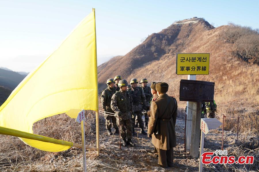 In this photo provided by South Korea Defense Ministry, South Korean army soldiers, wearing helmets, prepare to cross the Military Demarcation Line as North Korean army soldiers stand inside the Demilitarized Zone (DMZ) to inspect the dismantled North Korean guard post in the central section of the inter-Korean border in Cheorwon, Dec. 12, 2018. Dozens of soldiers from two countries crossed over the world\'s most heavily armed border Wednesday as they inspected the sites of their rival\'s front-line guard posts to verify they\'d been removed. (Photo provided by South Korea Defense Ministry)