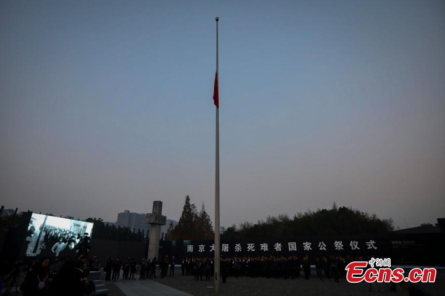 A national flag is flown at half-mast Thursday morning at the Memorial Hall for the Victims of the Nanjing Massacre, Dec. 13, 2018. On Thursday, China marked the fifth national memorial day to commemorate the victims of the Nanjing Massacre, in which Japanese invaders slaughtered about 300,000 Chinese during a six-week rampage after they captured the city, then China\'s capital, in 1937. In front of the darkly-dressed crowd at the ceremony, China\'s national flag is flown at half-mast. In February 2014, China\'s top legislature designated December 13 as the National Memorial Day for Nanjing Massacre Victims. (Photo: China News Service/Yang Bo)