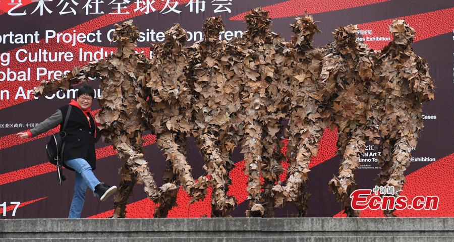 A woman poses photo with a foliage artwork at the West Lake in Hangzhou, Zhejiang Province, Dec. 12, 2108. Hosted by China Academy of Art, the Foliage Artwork Festival attracted many visitors. (Photo: China News Service/Wang Gang)