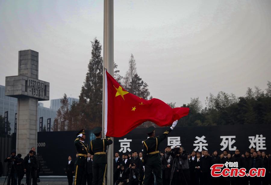 A national flag is flown at half-mast Thursday morning at the Memorial Hall for the Victims of the Nanjing Massacre, Dec. 13, 2018. On Thursday, China marked the fifth national memorial day to commemorate the victims of the Nanjing Massacre, in which Japanese invaders slaughtered about 300,000 Chinese during a six-week rampage after they captured the city, then China\'s capital, in 1937. In front of the darkly-dressed crowd at the ceremony, China\'s national flag is flown at half-mast. In February 2014, China\'s top legislature designated December 13 as the National Memorial Day for Nanjing Massacre Victims. (Photo: China News Service/Yang Bo)