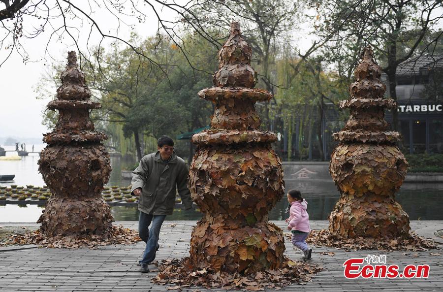 People play around a foliage artwork at the West Lake in Hangzhou, Zhejiang Province, Dec. 12, 2108. Hosted by China Academy of Art, the Foliage Artwork Festival attracted many visitors. (Photo: China News Service/Wang Gang)