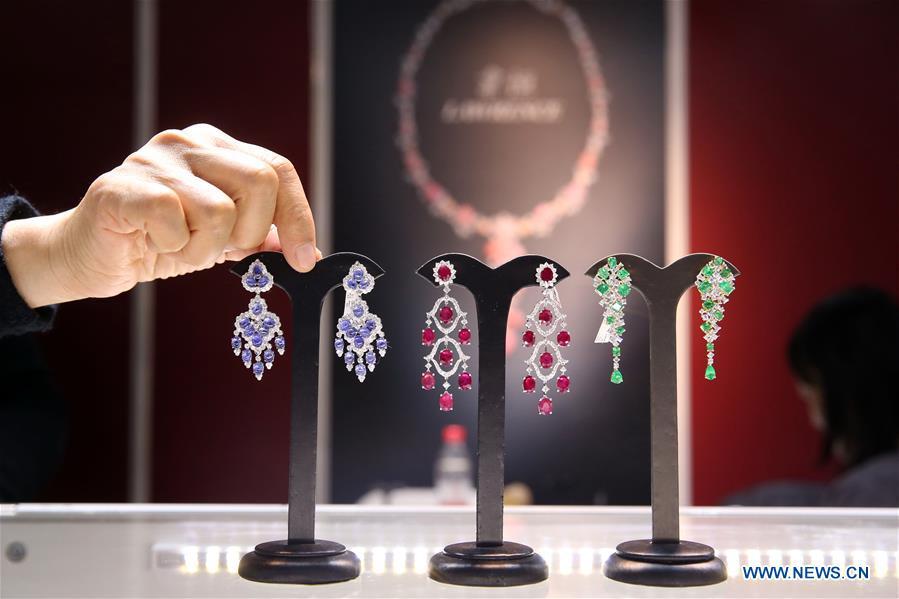 A staff worker arranges exhibits at the 2018 China International Jewelry Fair in Beijing, capital of China, Dec. 13, 2018. Exhibitors from 23 countries and regions attended the fair, opened on Thursday. (Xinhua/Chen Xiaogen)