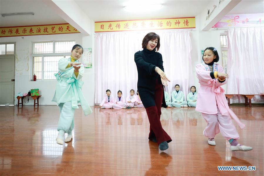 Bi Chunmei (C), a performer of Xuyi Huangmei Opera Troupe, teaches students Huangmei Opera at Wudun Primary School, in Xuyi County of east China\'s Jiangsu Province, Dec. 16, 2018. Performers of the troupe have been teaching local students Huangmei Opera in recent years to promote the traditional opera. (Xinhua/Zhou Haijun)