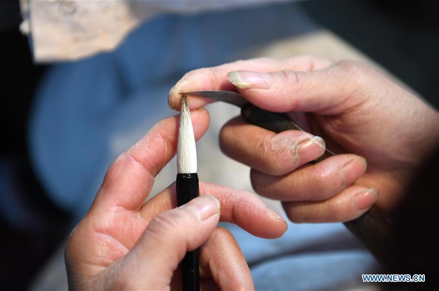 A worker makes the Xuan ink brush at a workshop in Huangcun Town of Jingxian County, east China\'s Anhui Province, Dec. 14, 2018. Huangcun Town has a long history of the Xuan ink brush making. The ink brush, ink, Chinese Xuan paper and ink slabs are four traditional writing materials of Chinese stationery. (Xinhua/Liu Junxi)