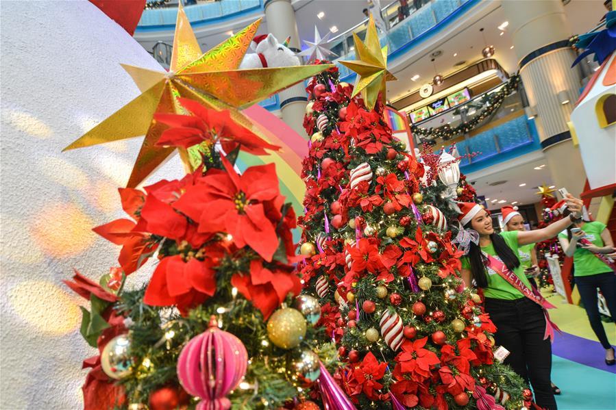 A woman takes selfies in front of Christmas trees in Kuala Lumpur, Malaysia, on Dec. 16, 2018. (Xinhua/Chong Voon Chung)