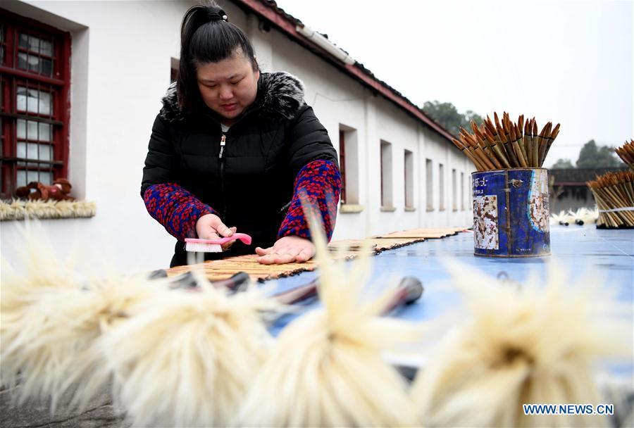 A worker dries the Xuan ink brushes at a workshop in Huangcun Town of Jingxian County, east China\'s Anhui Province, Dec. 14, 2018. Huangcun Town has a long history of the Xuan ink brush making. The ink brush, ink, Chinese Xuan paper and ink slabs are four traditional writing materials of Chinese stationery. (Xinhua/Liu Junxi)