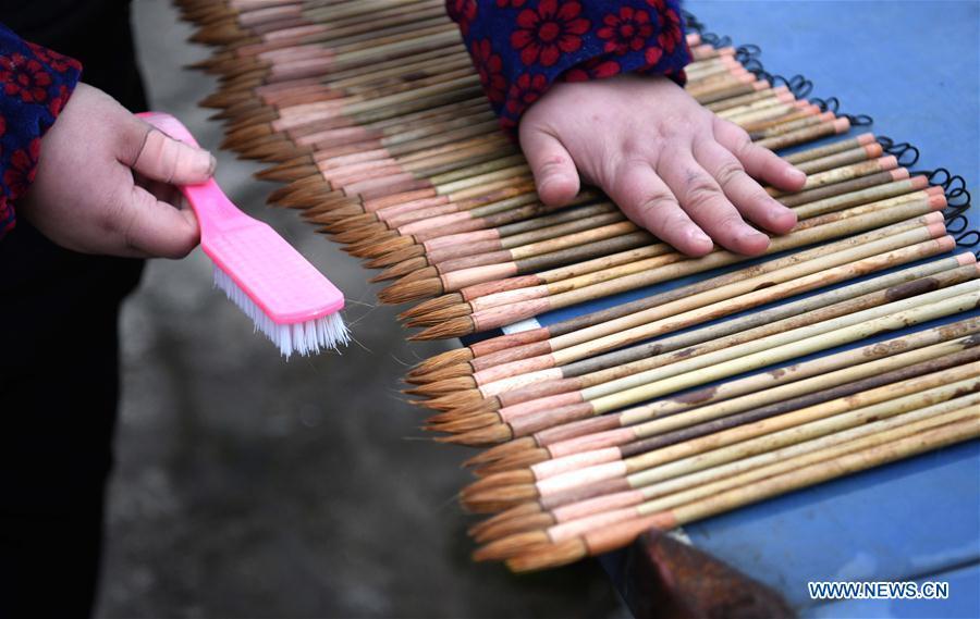 A worker dries the Xuan ink brushes at a workshop in Huangcun Town of Jingxian County, east China\'s Anhui Province, Dec. 14, 2018. Huangcun Town has a long history of the Xuan ink brush making. The ink brush, ink, Chinese Xuan paper and ink slabs are four traditional writing materials of Chinese stationery. (Xinhua/Liu Junxi)