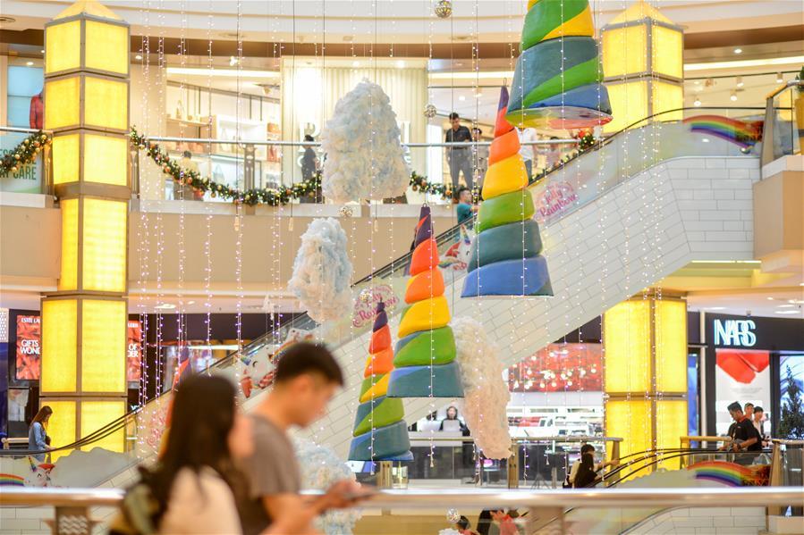 Customers walk past decorations set up for the upcoming Christmas season at a shopping mall in Kuala Lumpur, Malaysia, on Dec. 16, 2018. (Xinhua/Chong Voon Chung)