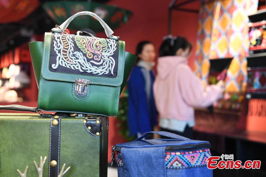 A store features products that integrate the intangible cultural heritages of the Zhuang people in Nanning City, Southwest China\'s Guangxi Zhuang Autonomous Region, Dec. 17, 2018. The products, including leatherware, clothes and bags, highlight the unique crafts of the Zhuang people. (Photo: China News Service/Yu Jing)