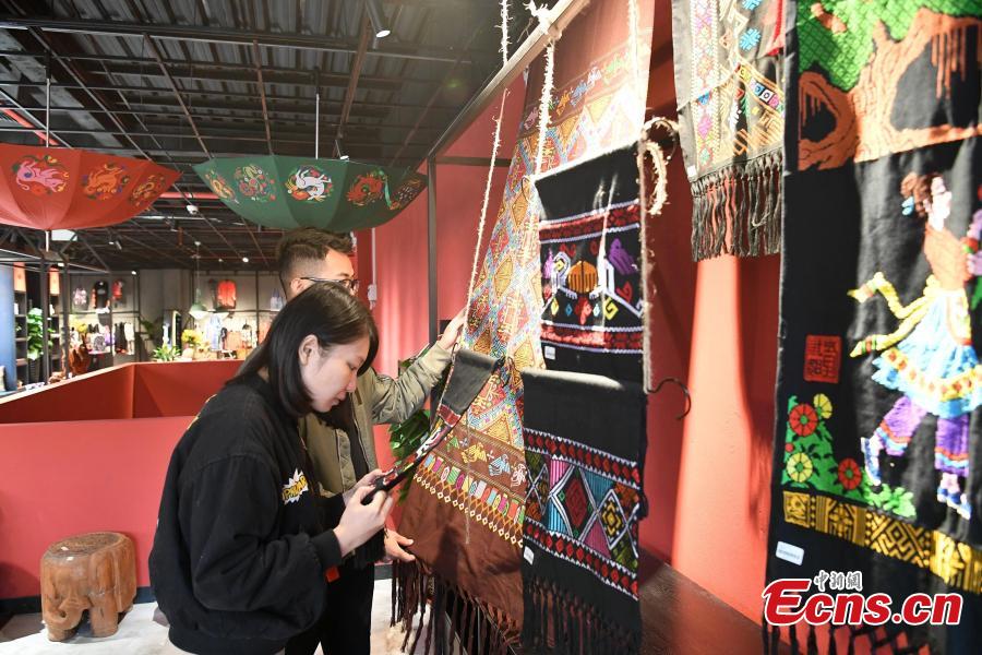 A store features products that integrate the intangible cultural heritages of the Zhuang people in Nanning City, Southwest China\'s Guangxi Zhuang Autonomous Region, Dec. 17, 2018. The products, including leatherware, clothes and bags, highlight the unique crafts of the Zhuang people. (Photo: China News Service/Yu Jing)