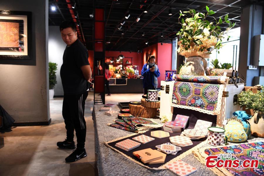 A store features products that integrate the intangible cultural heritages of the Zhuang people in Nanning City, Southwest China\'s Guangxi Zhuang Autonomous Region, Dec. 17, 2018. The products, including leatherware, clothes and bags, highlight the unique crafts of the Zhuang people. (Photo: China News Service/Yu Jing)