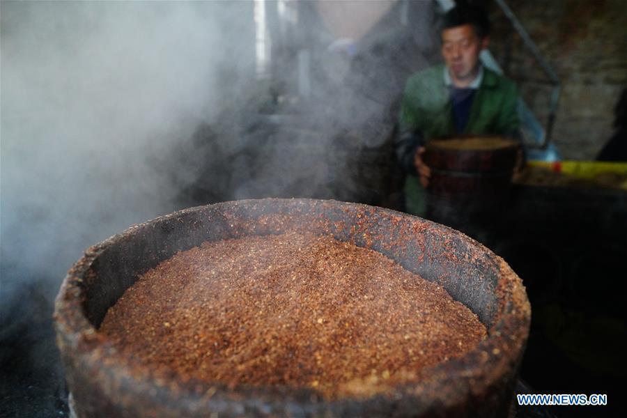 Villager Tan Han steams camellia seeds for oil extraction in Licha Village of Longsheng County, south China\'s Guangxi Zhuang Autonomous Region, Dec. 17, 2018. Camellia oil made with traditional methods by workshops in the village is quite popular in market because of its better quality and longer guarantee. (Xinhua/Huang Yongdan)