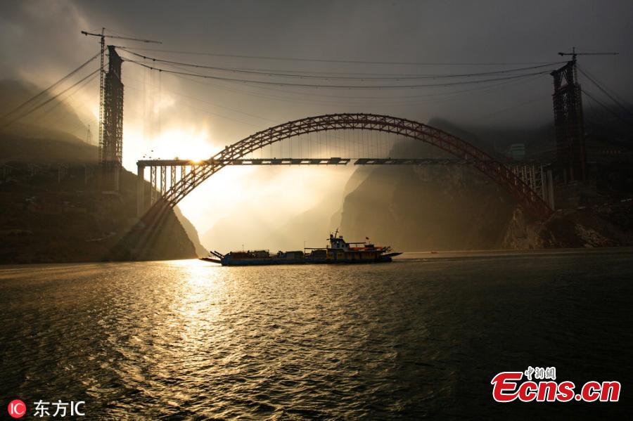 Sunrise at the construction site of a bridge over the Yangtze River in Zigui County, Central China\'s Hubei Province. The confluence of Xiangxi Stream, a tributary of China\'s greatest river, and Xiling Gorge, one of the Three Gorges, is a tourist attraction renowned for its magnificent scenic beauty. (Photo/IC)