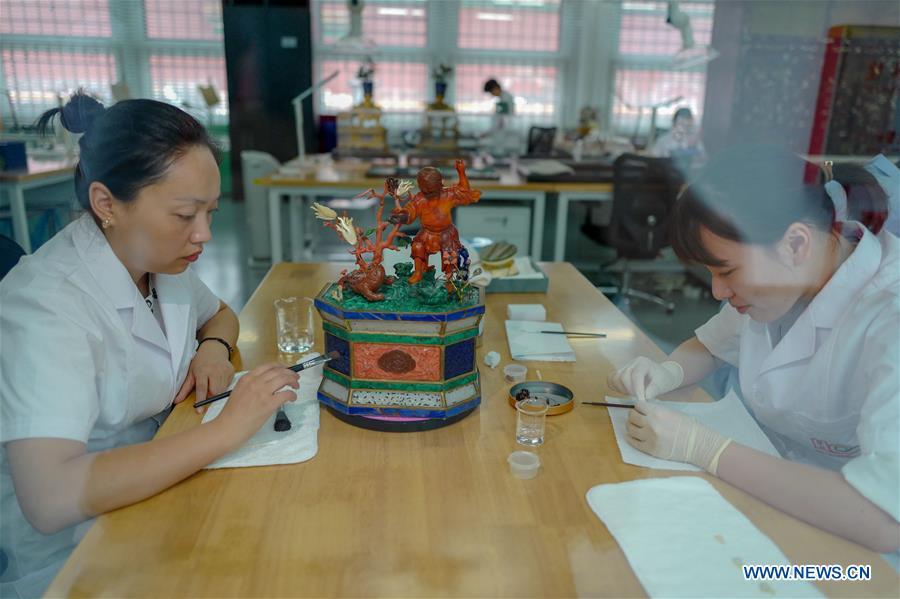 Staff workers repair museum collections at a hospital for conservation in the Palace Museum in Beijing, capital of China, June 9, 2018. (Xinhua/Liu Chan)