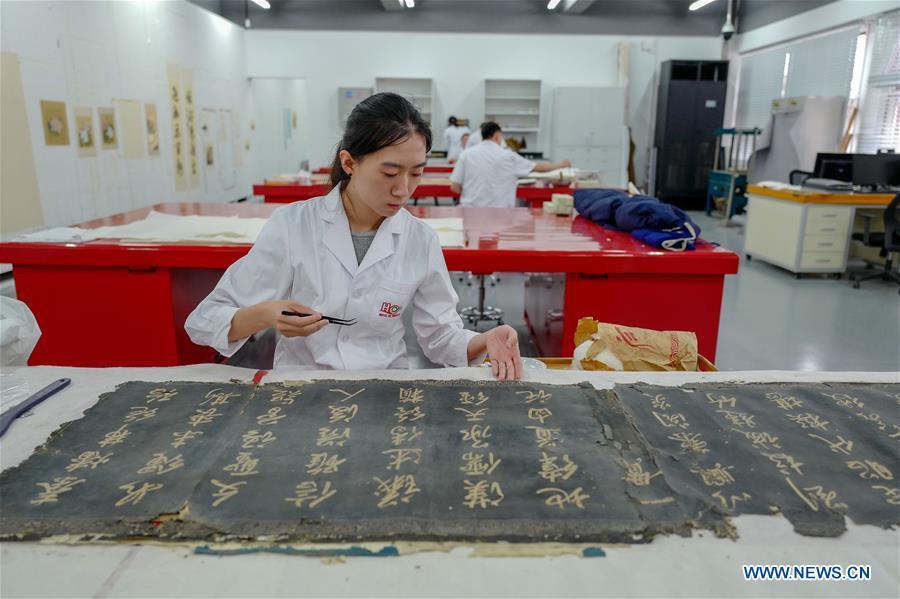 A staff worker repairs a calligraphy collection at a hospital for conservation in the Palace Museum in Beijing, capital of China, June 9, 2018. (Xinhua/Liu Chan)