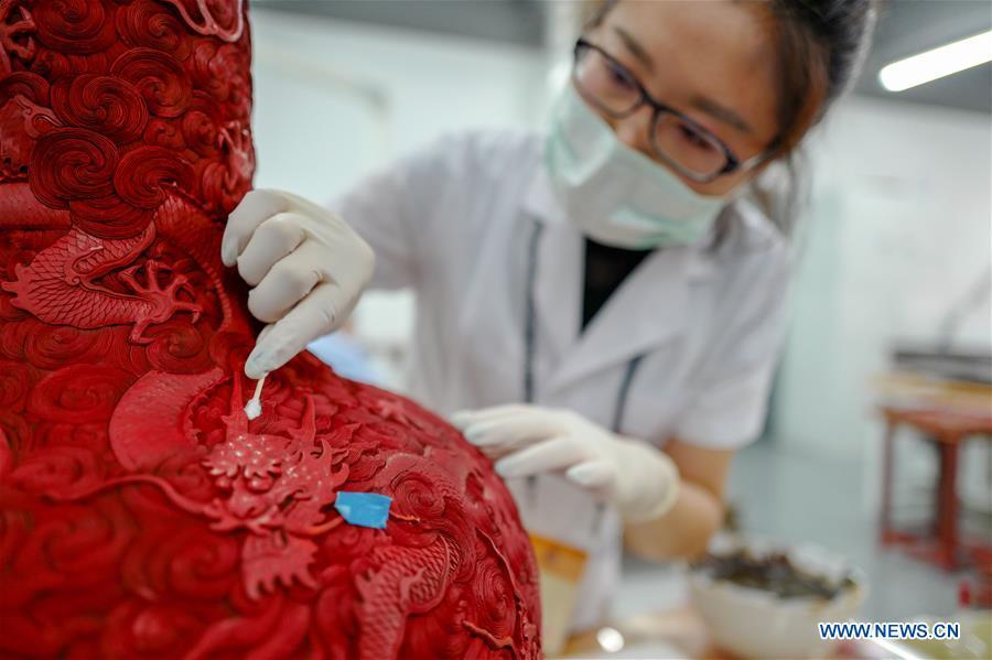 A staff worker wipes a museum collection at a hospital for conservation in the Palace Museum in Beijing, capital of China, June 9, 2018. (Xinhua/Liu Chan)
