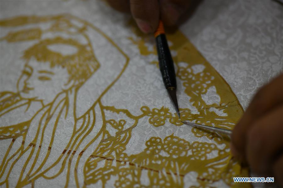 Niu Shimin creates a paper cutting work with leaves at his workshop in Wuji County, north China\'s Hebei Province, Dec. 19, 2018. Niu Shimin has been interested in paper cutting since he was young. He created his own style through over 30 years of practicing and was awarded as the inheritor of this provincial intangible cultural heritage in 2008. (Xinhua/Chen Qibao)