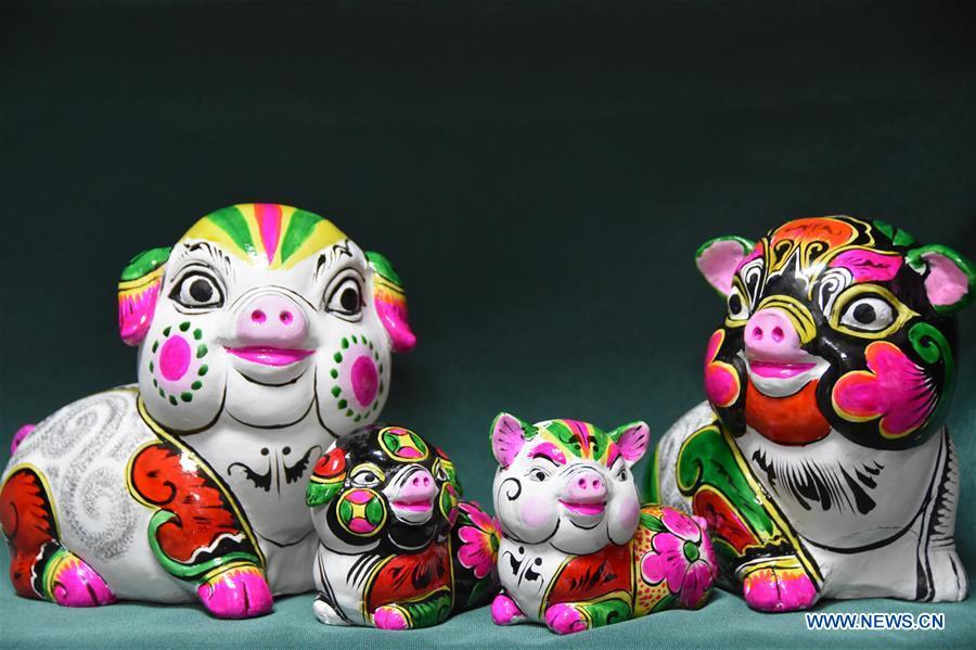 Photo taken on Dec. 20, 2018 shows clay pig sculptures designed by master Hu Xinming in Liuying Village of Fengxiang County, northwest China\'s Shaanxi Province. Artists of Liuying Village of Fengxiang County, known as the hometown of clay sculpture, were busy making clay sculptures to greet the upcoming Chinese lunar new year, the Year of the Pig. (Xinhua/Du Honggang)