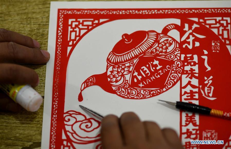 Niu Shimin creates a paper cutting work at his workshop in Wuji County, north China\'s Hebei Province, Dec. 19, 2018. Niu Shimin has been interested in paper cutting since he was young. He created his own style through over 30 years of practicing and was awarded as the inheritor of this provincial intangible cultural heritage in 2008. (Xinhua/Chen Qibao)