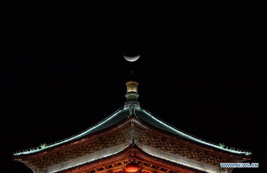 Photo taken on Jan. 31, 2018 shows a moon on the top of the Bell Tower in Xi\'an, capital city of northwest China\'s Shaanxi Province. The living and working scenes of Chinese people in the past year have created a series of amazing views, some of which formed geometric figures. Those photos tell the development and progress of the country in 2018. (Xinhua/Li Yibo)