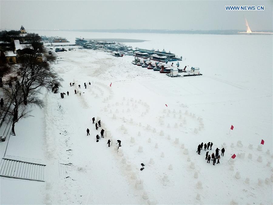 People make snowmen on the frozen Songhua River in Harbin, capital of northeast China\'s Heilongjiang Province, Dec. 21, 2018. Altogether 2,019 cute snowmen will be displayed here before January 1, 2019 to greet the new year. (Xinhua/Wang Song)