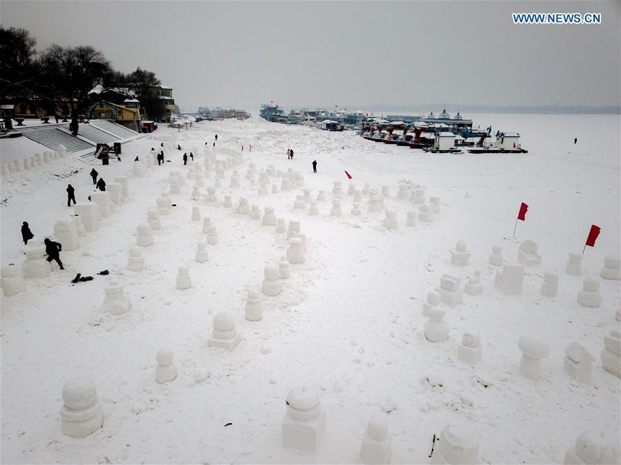 People make snowmen on the frozen Songhua River in Harbin, capital of northeast China\'s Heilongjiang Province, Dec. 21, 2018. Altogether 2,019 cute snowmen will be displayed here before January 1, 2019 to greet the new year. (Xinhua/Wang Song)