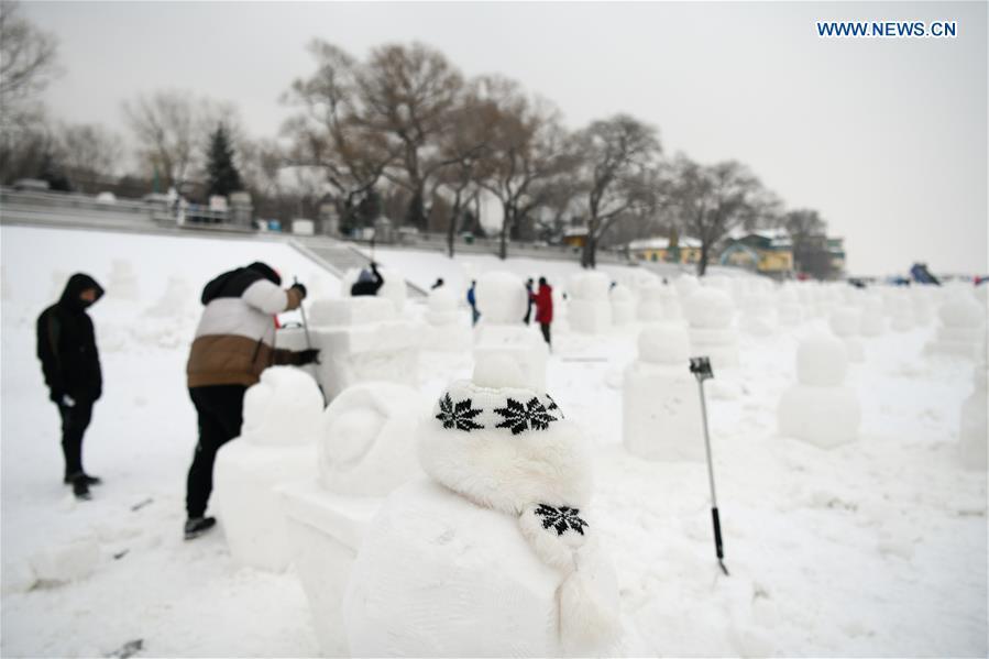 People make snowmen on the frozen Songhua River in Harbin, capital of northeast China\'s Heilongjiang Province, Dec. 21, 2018. Altogether 2,019 cute snowmen will be displayed here before January 1, 2019 to greet the new year. (Xinhua/Wang Song)