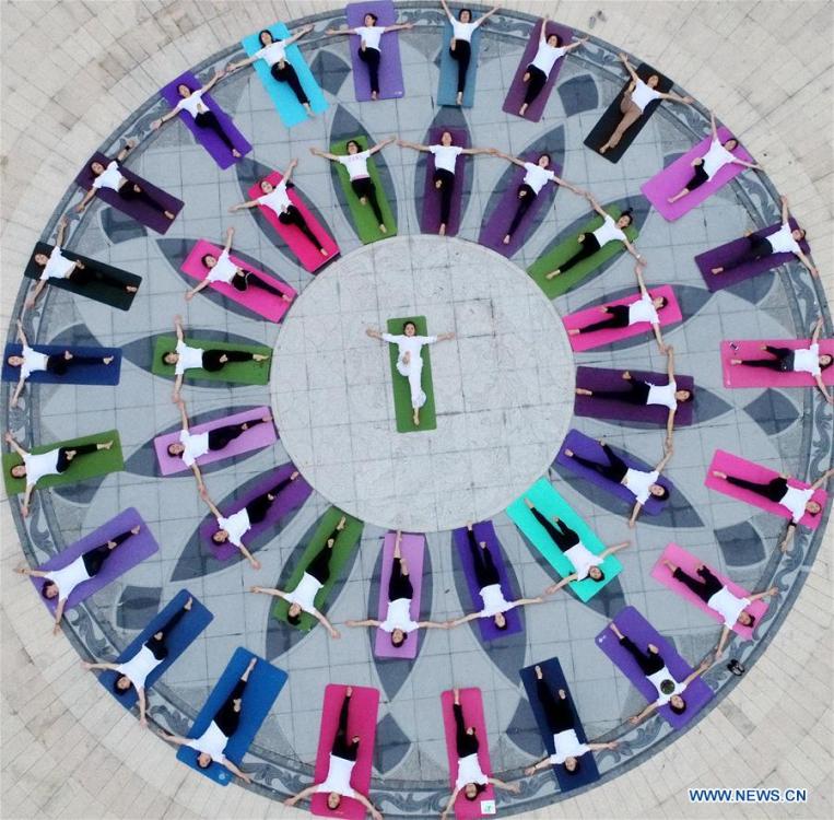 People take part in a yoga practice at the Baihua Park in Xiajiang County, east China\'s Jiangxi Province, June 21, 2018. The living and working scenes of Chinese people in the past year have created a series of amazing views, some of which formed geometric figures. Those photos tell the development and progress of the country in 2018. (Xinhua/Chen Fuping)