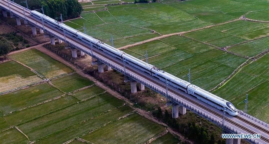Photo taken on March 7, 2018 shows a bullet train running on the western track of the high-speed loop line in Changjiang Li Autonomous County, south China\'s Hainan Province. The living and working scenes of Chinese people in the past year have created a series of amazing views, some of which formed geometric figures. Those photos tell the development and progress of the country in 2018. (Xinhua/Yang Guanyu)