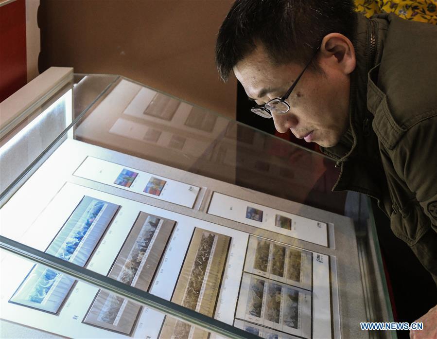 A man looks at the stamps displayed during a major exhibition to commemorate the 40th anniversary of China\'s reform and opening-up at the National Museum of China in Beijing, capital of China, Dec. 22, 2018. The exhibition has received more than 1.85 million visitors since its opening. (Xinhua/Li He)