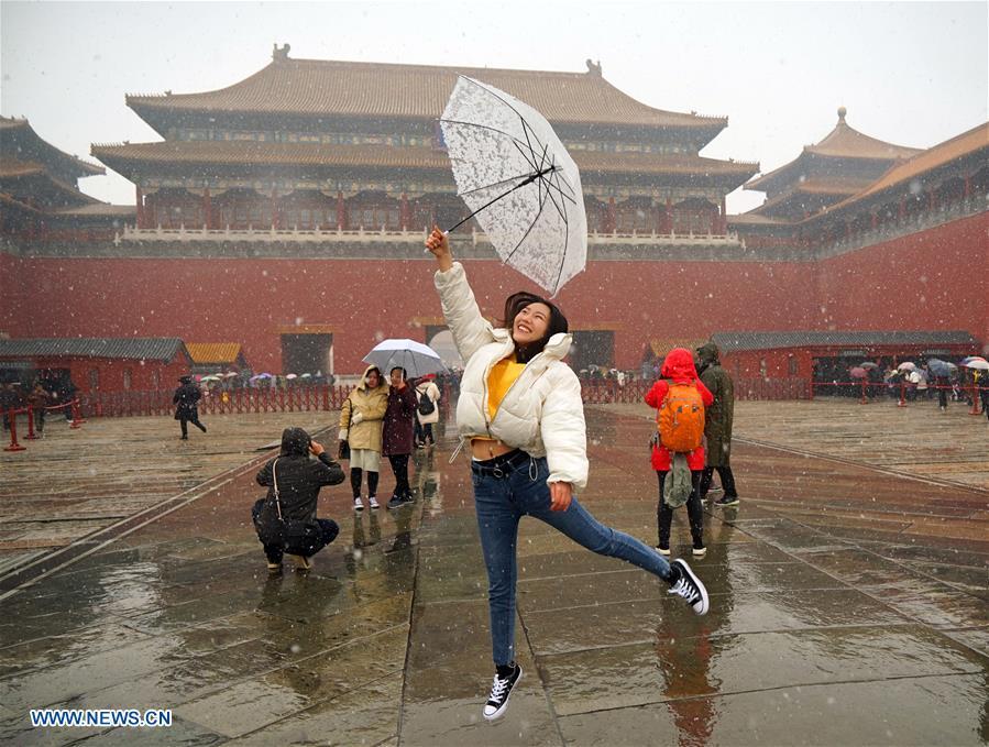 A tourist poses for photos in snow at the Palace Museum in Beijing, capital of China, March 17, 2018. The Palace Museum, or the former imperial palace in downtown Beijing, will open 85 percent of its areas to the public, compared with the current 80 percent, the China Daily reported Friday. Most of the areas inside the museum, also known as the Forbidden City, will no longer be off-limits for the public, the newspaper quoted Shan Jixiang, the museum\'s curator, as saying. The biggest of its kind in the world, the Forbidden City is gradually opening more of its coverage of 720,000 square meters to visitors in recent years. Only 30 percent of its areas were accessible by the public in 2012. Some rooms that had not been opened for decades were used as \