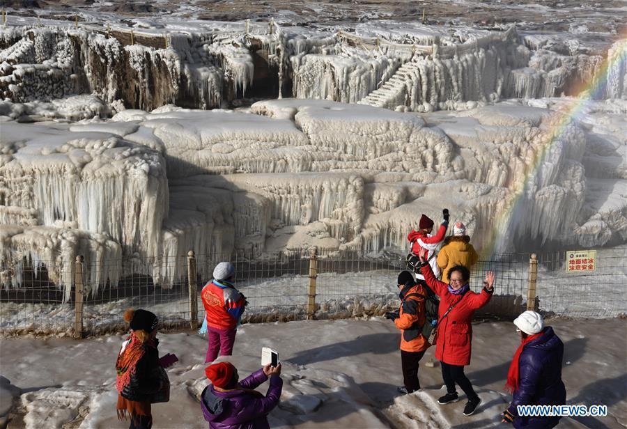 Tourists take photos of icicles of the Hukou Waterfall of the Yellow River in Jixian County, north China\'s Shanxi Province, Dec. 23, 2018. (Xinhua/Lyu Guiming)