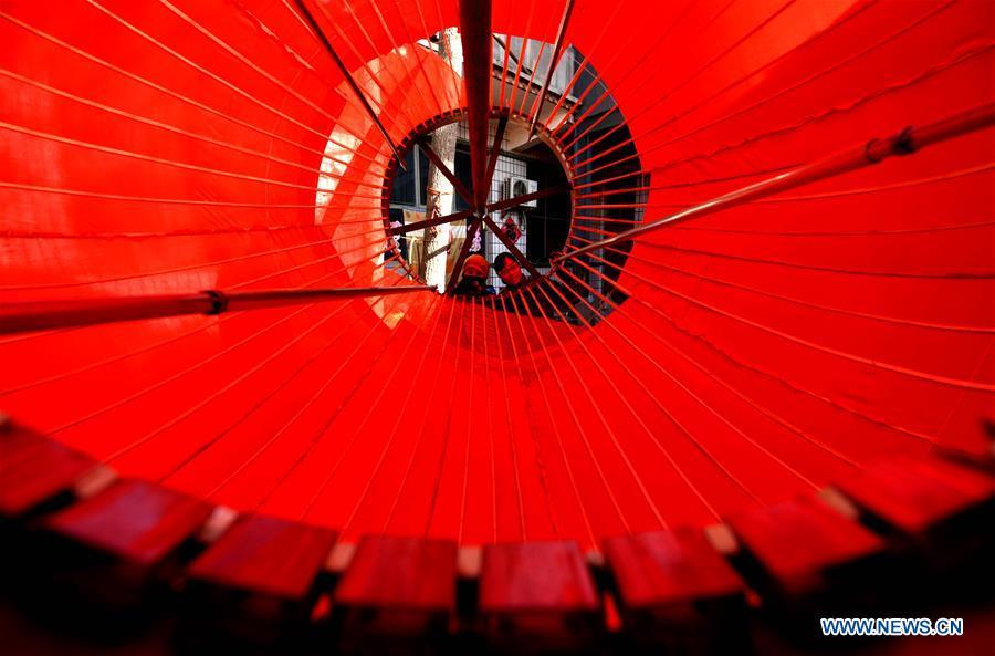 Workers make a big red lantern in Tuntou Village, Gaocheng District, Shijiazhuang City, north China\'s Hebei Province, Dec. 23, 2018. As the New Year approaches, lantern craftsmen in Gaocheng, which is known for its lantern manufacturing, are busy making red lanterns. (Xinhua/Chen Qibao)