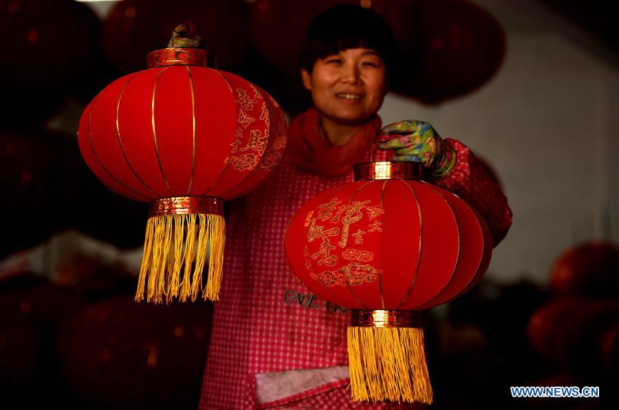 A worker shows red lanterns in Tuntou Village, Gaocheng District, Shijiazhuang City, north China\'s Hebei Province, Dec. 23, 2018. As the New Year approaches, lantern craftsmen in Gaocheng, which is known for its lantern manufacturing, are busy making red lanterns. (Xinhua/Chen Qibao)