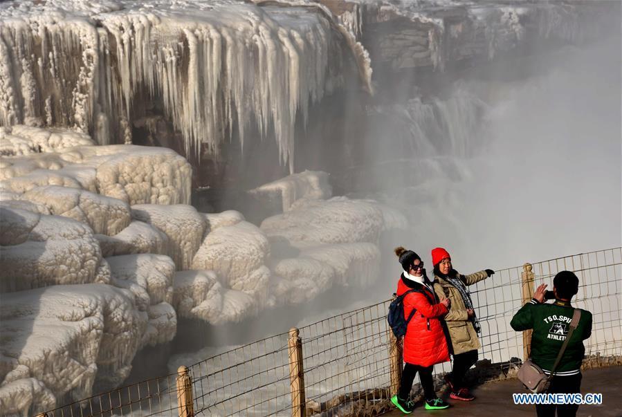 Tourists take photos of icicles of the Hukou Waterfall of the Yellow River in Jixian County, north China\'s Shanxi Province, Dec. 23, 2018. (Xinhua/Lyu Guiming)