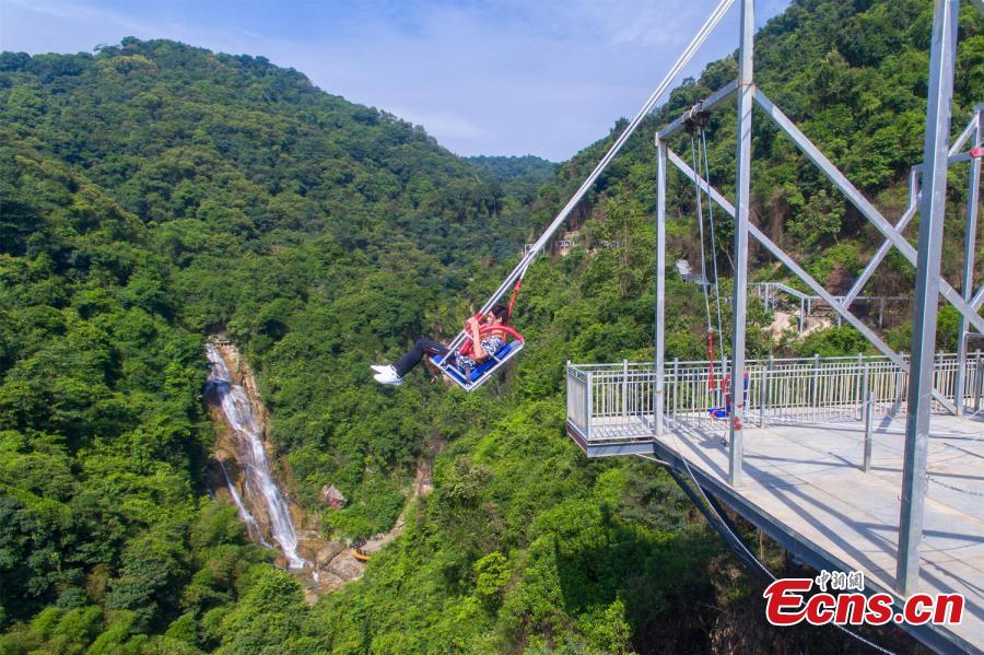 Photo shows a tourist experiencing the cliff swing that officially opened to the public in Qingyuan, Guangdong Province on December 19, 2018. The swing above a 198-meter waterfall on Mount Tianzi in Qingyuan, South China\'s Guangdong Province officially opens on Thursday after a four-month trial operation.  (Photo: China News Service/Cheng Jingwei)