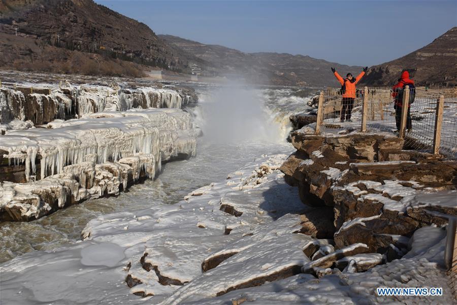 Tourists take photos of icicles of the Hukou Waterfall of the Yellow River in Jixian County, north China\'s Shanxi Province, Dec. 23, 2018. (Xinhua/Lyu Guiming)