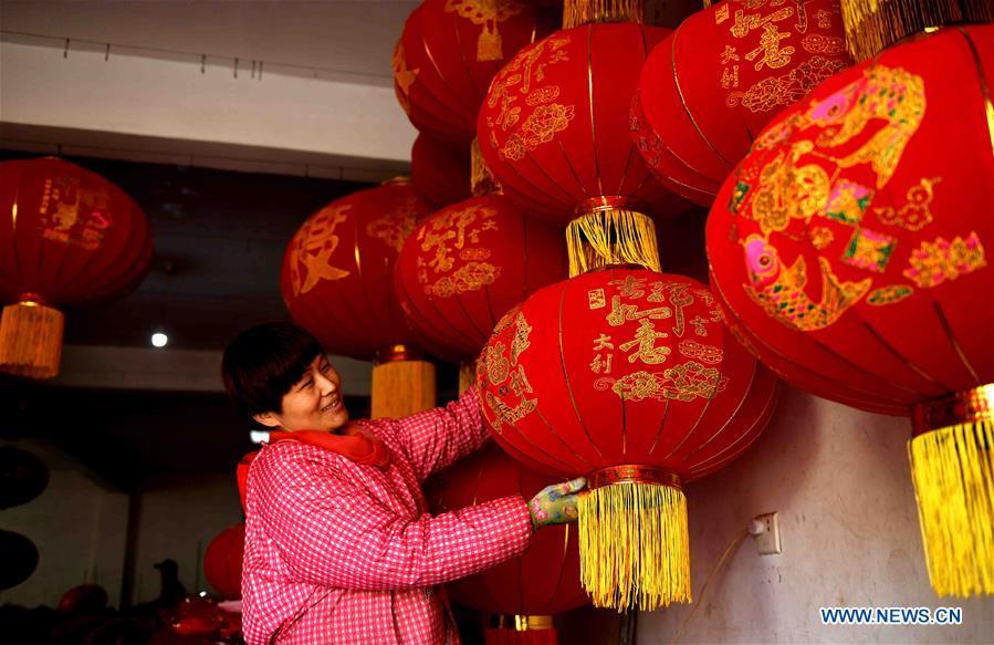 A worker shows red lanterns in Tuntou Village, Gaocheng District, Shijiazhuang City, north China\'s Hebei Province, Dec. 23, 2018. As the New Year approaches, lantern craftsmen in Gaocheng, which is known for its lantern manufacturing, are busy making red lanterns. (Xinhua/Chen Qibao)