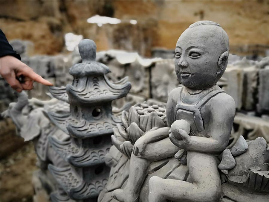 Liu Quan shows one of his works. (Photo by Wei Jianjun for chinadaily.com.cn)