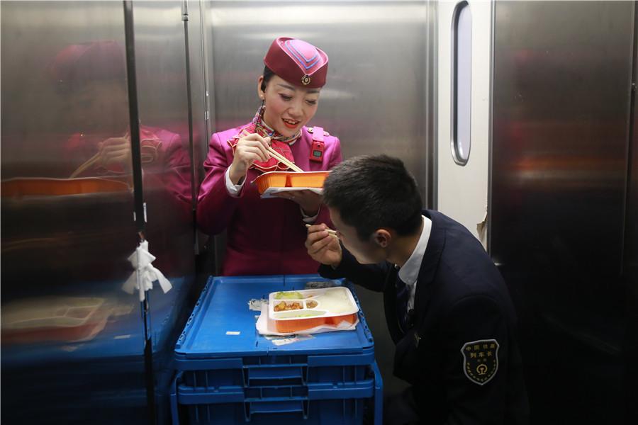 Liu Yuting and an intern conductor take time to eat lunch during a stop.  (Photo provided to chinadaily.com.cn)