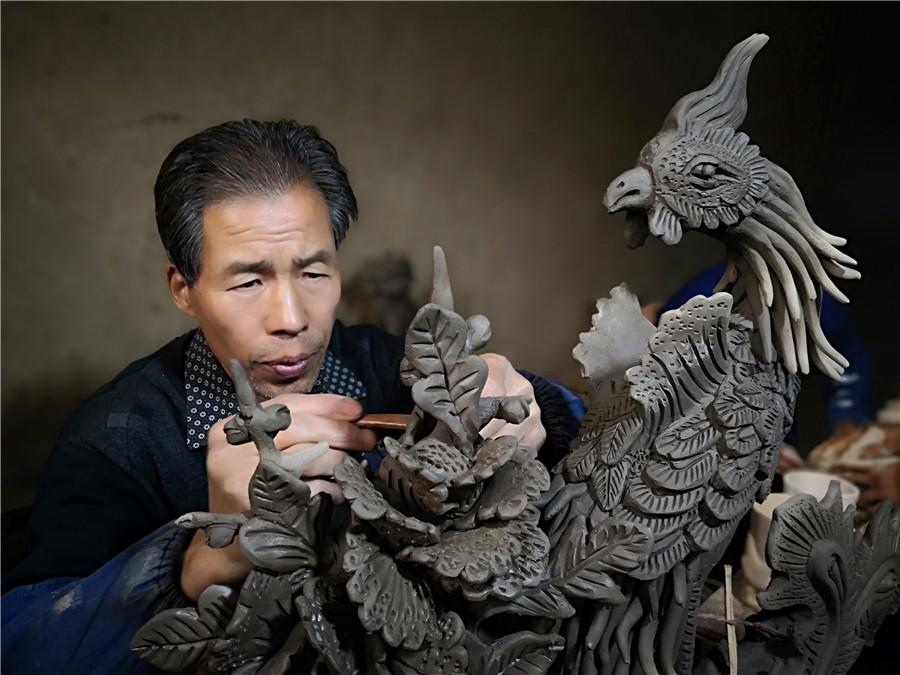 Liu Quan carves a phoenix, a bird from traditional Chinese myths. (Photo by Wei Jianjun for chinadaily.com.cn)
