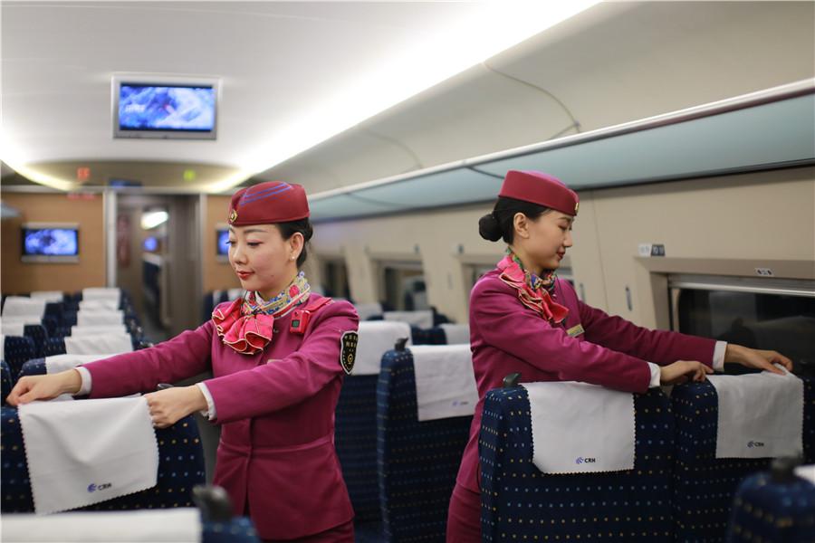Liu and her colleague tidy up the seat covers during a train stop to prepare for the coming of passengers. (Photo provided to chinadaily.com.cn)
