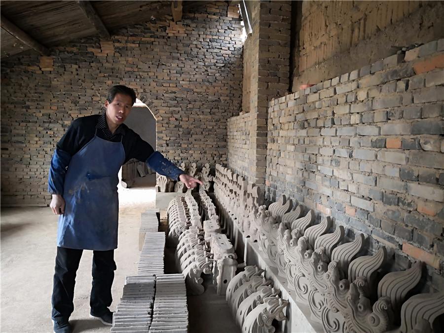 Liu Quan and his sculptures.  (Photo by Wei Jianjun for chinadaily.com.cn)
