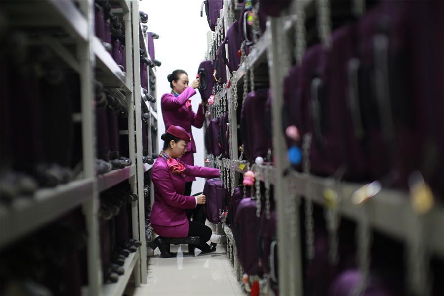 Liu picks up her suitcase from a rack at the staff area for attendants. (Photo provided to chinadaily.com.cn)