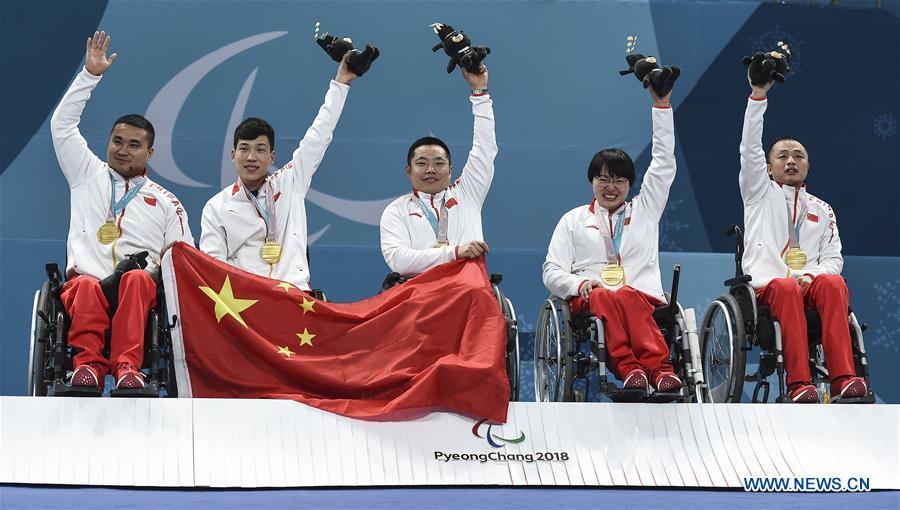 File photo taken on March 17, 2018 shows gold medalists, China\'s Wang Haitao, Chen Jianxin, Liu Wei, Wang Meng and Zhang Qiang (L to R) celebrate on the awarding ceremony after a 6-5 win over Norway in the wheelchair curling final at the 2018 PyeongChang Winter Paralympic Games at Gangneung, South Korea. It is the first-ever medal (and a gold one at that) for the Chinese delegation in the history of the Winter Paralympic Games. (Xinhua/Xia Yifang)